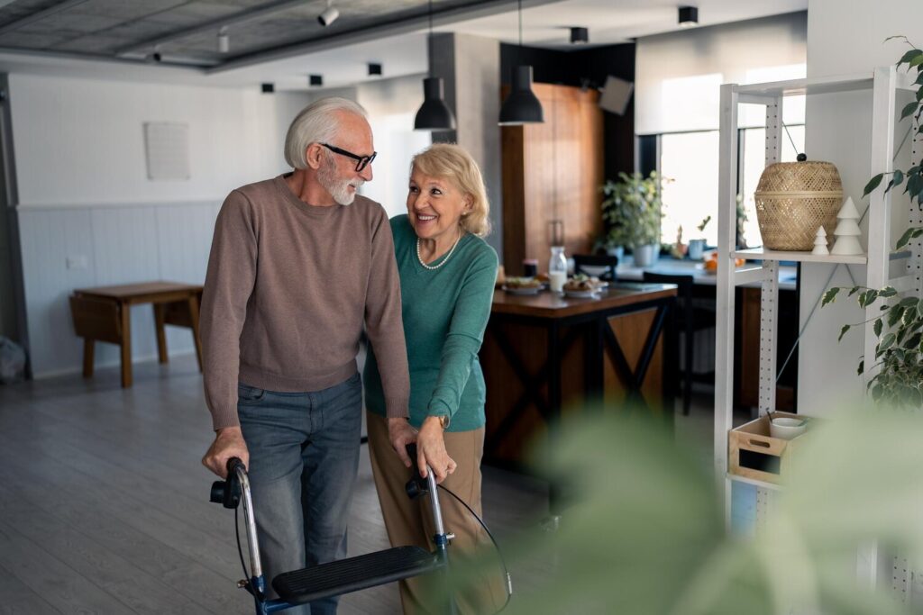 caring wife assisting her husband walk step by step with mobility walker home supportive wife helping husband use mobility walker elderly couple retirement together home 964806 2840
