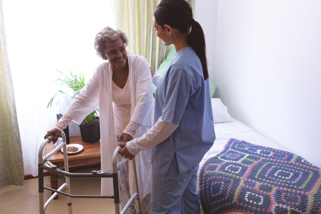 female nurse helping senior female patient stand with walker female nurse helping senior female patient stand with walker